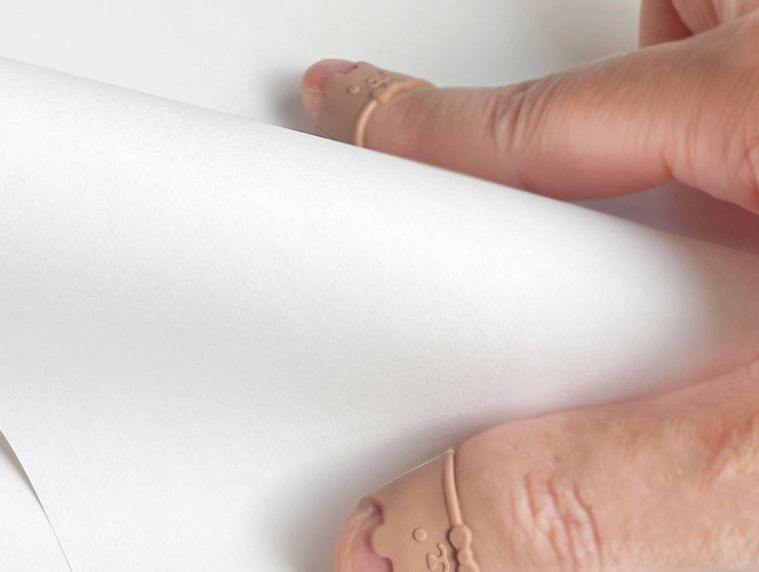 指サックをはめて紙をめくっている