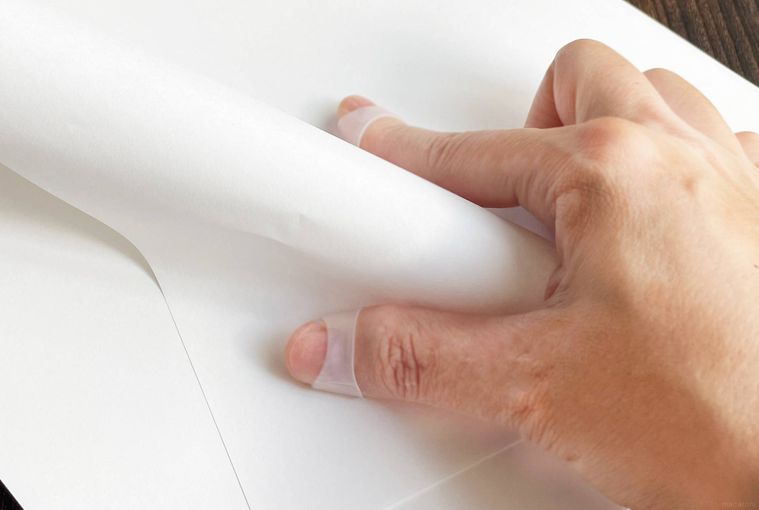 指サックをはめて紙をめくっている写真