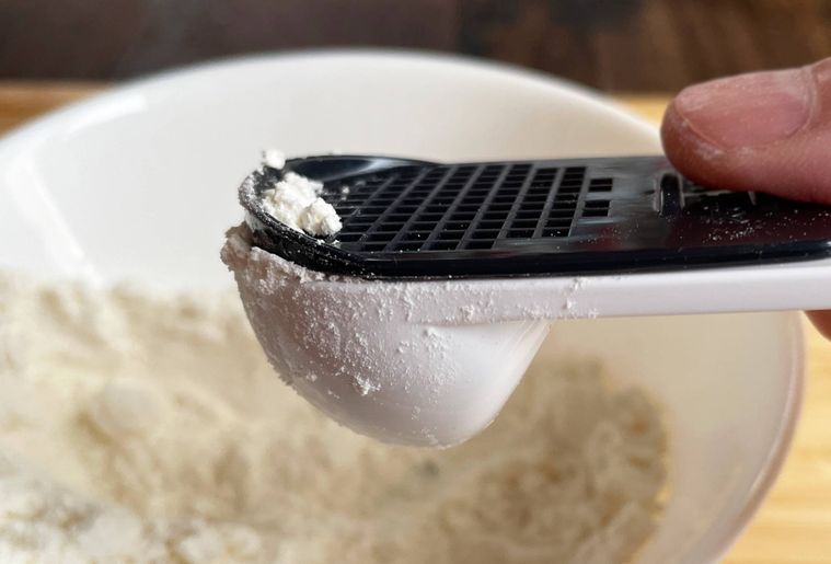 すりきり軽量スプーンで粉を量っている