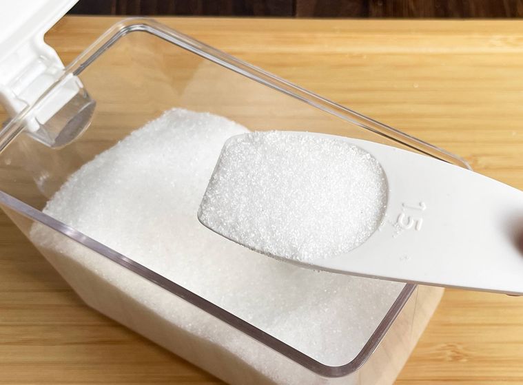計量スプーンで砂糖を量っている