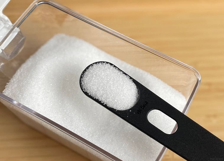 計量スプーンで砂糖を量っている