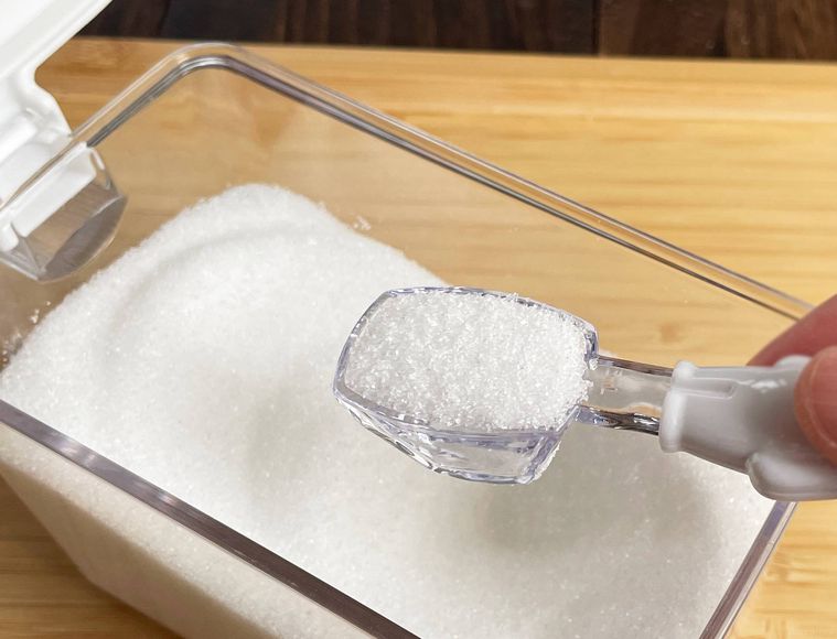 計量スプーンで砂糖を量っている