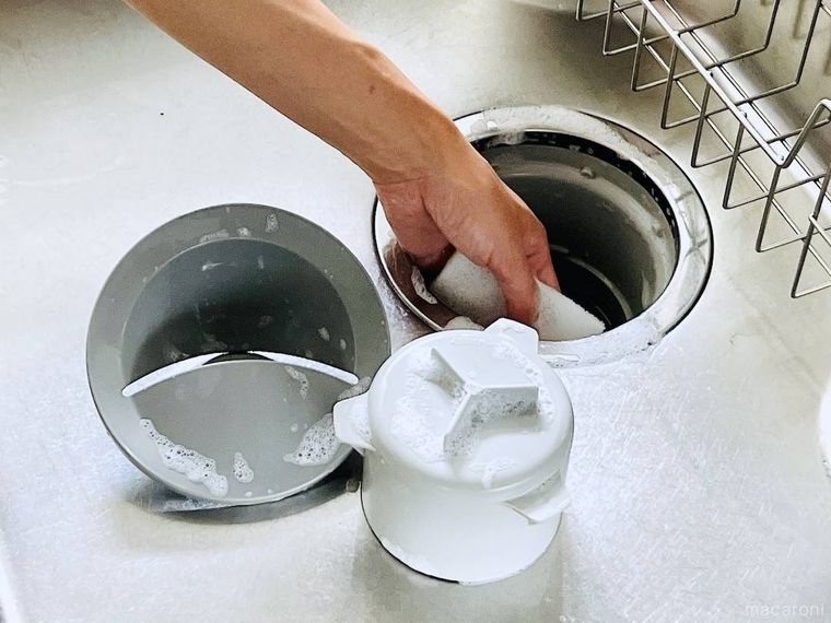 キッチンの排水口をスポンジで洗っている様子