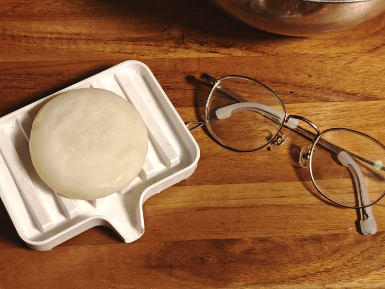 中性石鹸とメガネが机の上に置いてある