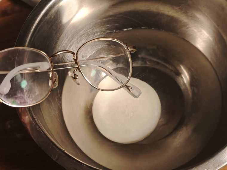中性石鹸で薄めた水にメガネを入れている