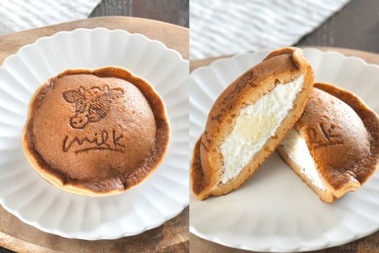 木のカッティングボードと白い皿にのった生クリーム入りのどらもっちの断面