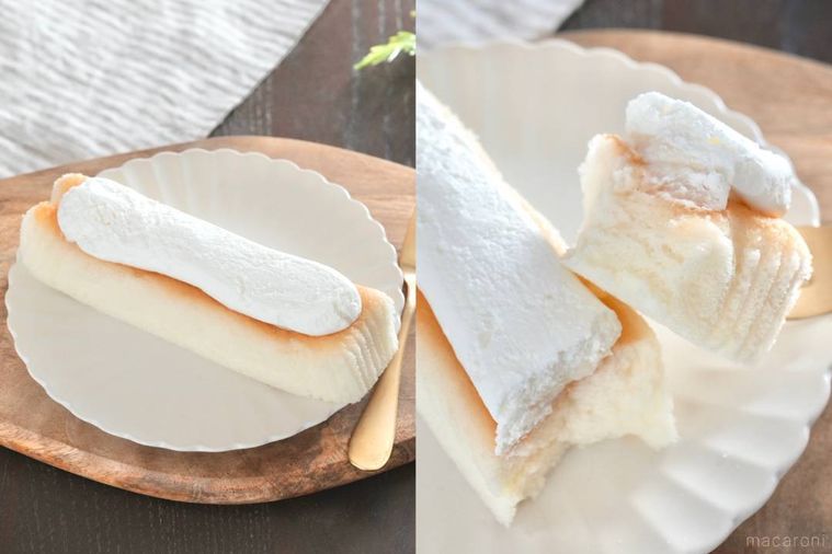 木のカッティングボードと白い皿にのった生クリームのせシフォンケーキを金のフォークで食べる様子