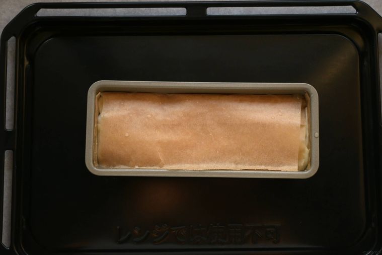 じゃがいもを詰め込んだパウンド型にクッキングシートで蓋がしてある