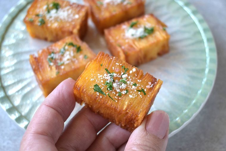 ひと口大のミルフィーユポテトを手で摘む様子