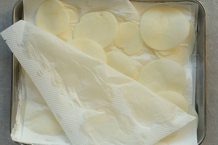 じゃがいもの水気をキッチンペーパーでふき取る様子