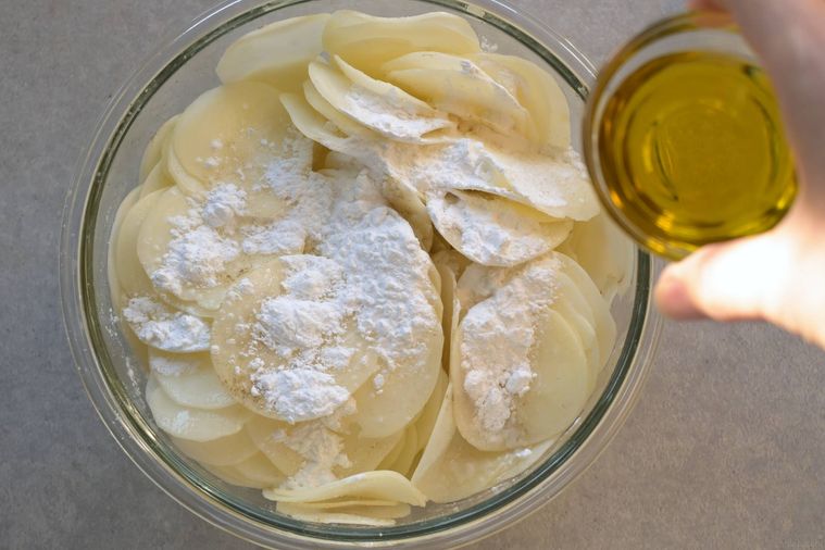 じゃがいもに塩・こしょう、コーンスターチ、オリーブオイルをかける様子