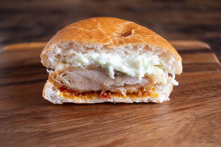 半分に割ったケンタッキーケンタの鶏竜田バーガーピリ辛しょうがが板の上にのっている