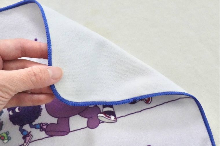 白いテーブルクロスと紫色のタオルハンカチを触る様子