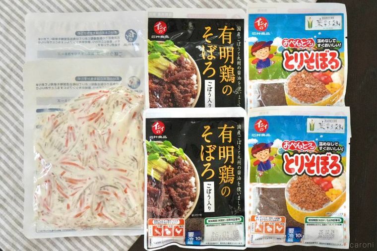 ストライプの布の上に並べられたごぼうサラダと2種類の鶏そぼろの加工食品