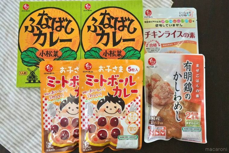 ストライプの布の上に並べられたカレーや混ぜごはんの素やチキンライスの素のパッケージ