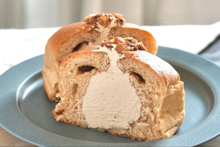 木のカッティングボードとグレーの皿にのったコーヒーホイップパンの断面