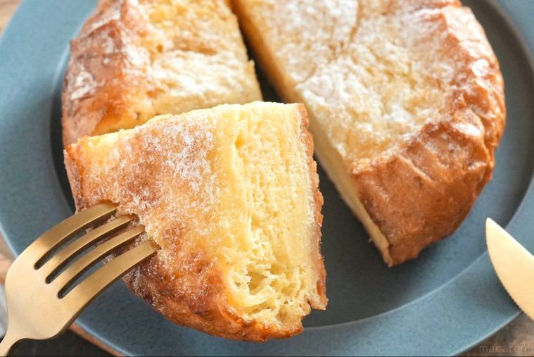 グレーの皿にのったフレンチトーストをフォークとナイフで食べる様子