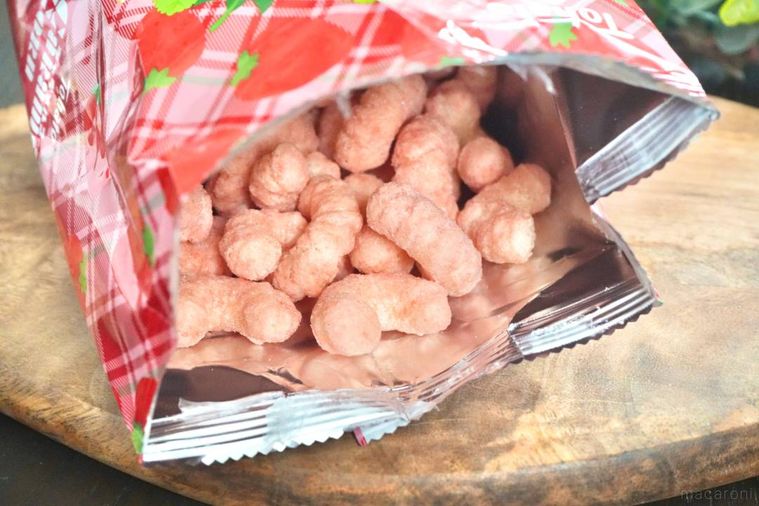 木のカッティングボードにのったあまおう苺味のキャラメルコーンの袋を開けた様子