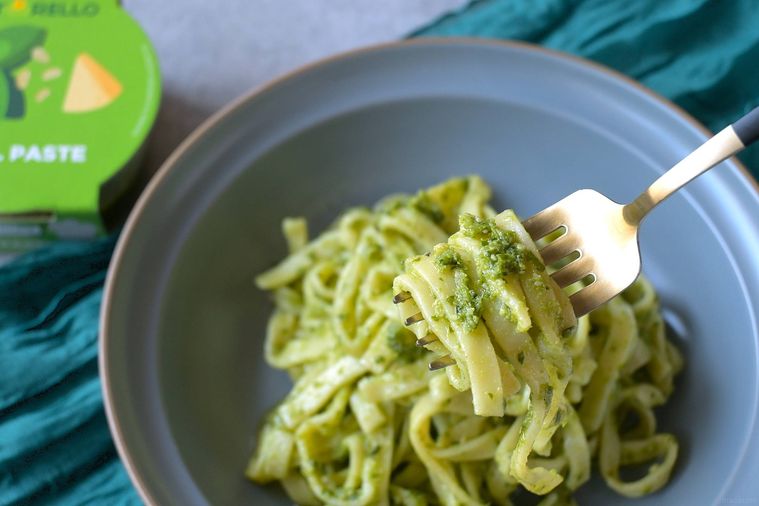 グレーの深皿に盛り付けられたバジルソースパスタをフォークで絡め取る様子