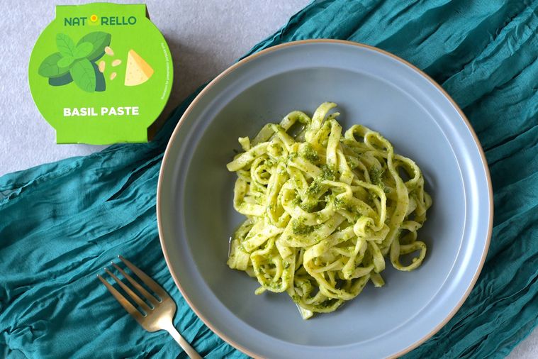 バジルペーストを絡めたフェットチーネがグレーの丸皿に盛り付けられている