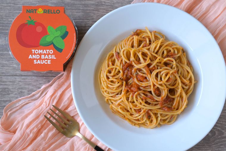 トマトバジルソースを絡めたスパゲッティが白い丸皿に盛り付けられている