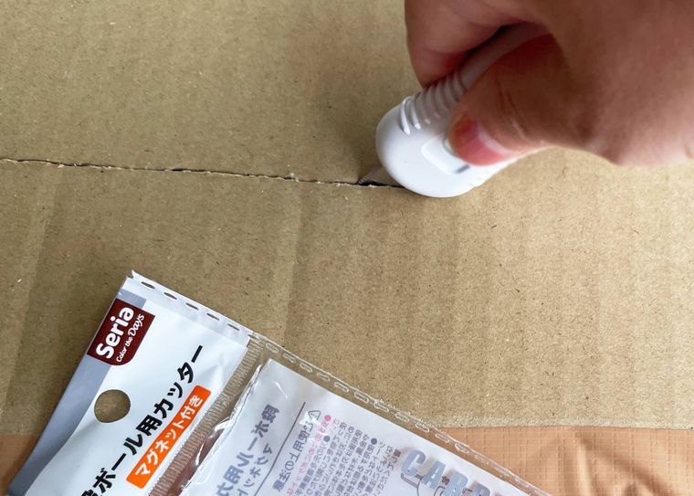 段ボール用カッターで段ボールをカットしているところ
