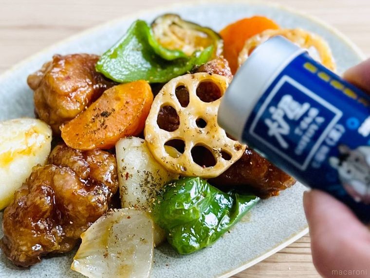 鶏と野菜の黒酢あんに七福味 黒をかけている様子