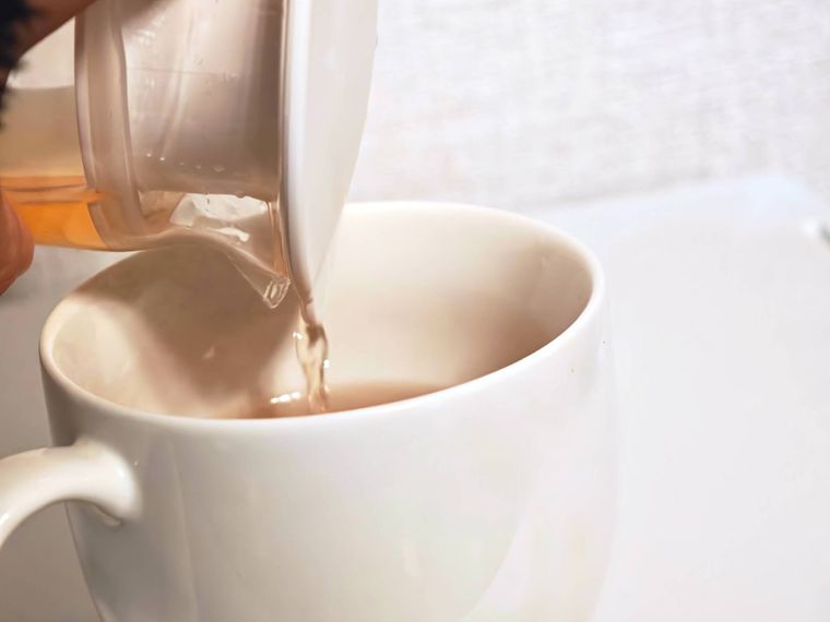 お茶が入ったウォーターポットをコップに注いでいる様子