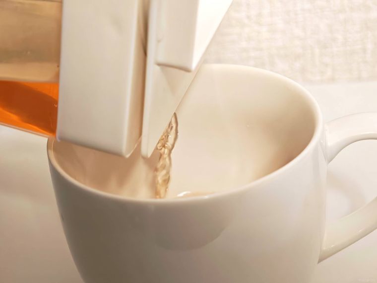 横置きできる冷水筒に入ったお茶をコップに注ぐ様子