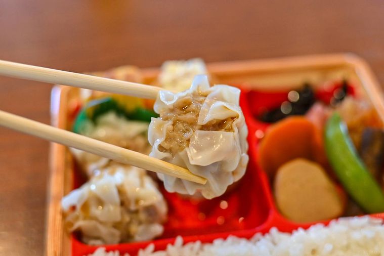 シュウマイを箸で持ち上げているところ