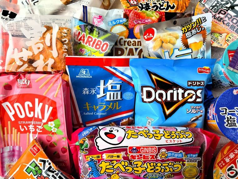 ローソン詰めすぎチャレンジ あふれそうなハッピー 2025福袋のお菓子やカップラーメンなどが並べられている様子