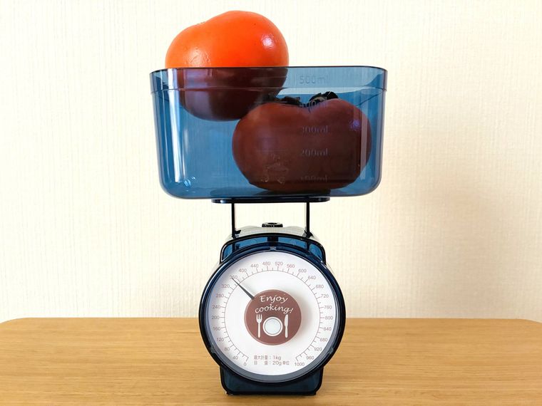 ダイソーのはかりで柿2個を量っている
