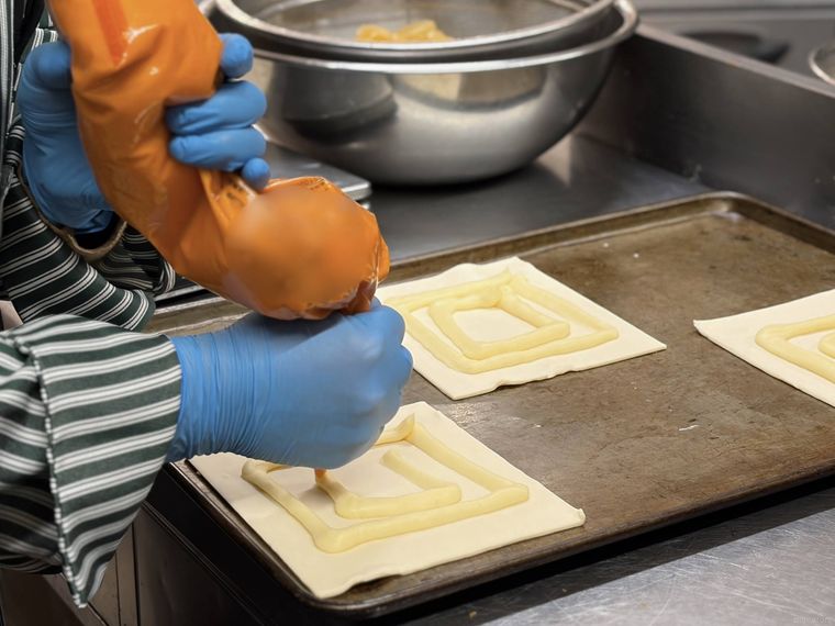 生地の上にカスタードクリームを絞る様子