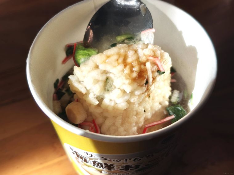 海鮮おこげスープをスプーンですくっている様子