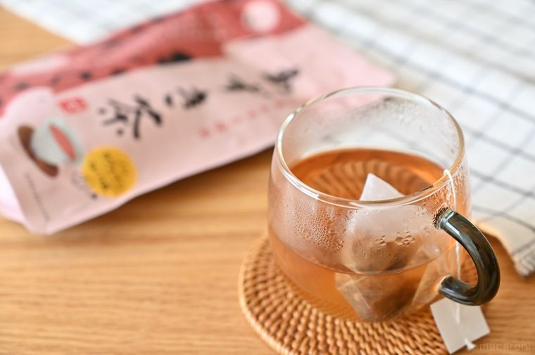 グラスに入ったホットあずき茶と商品パッケージ