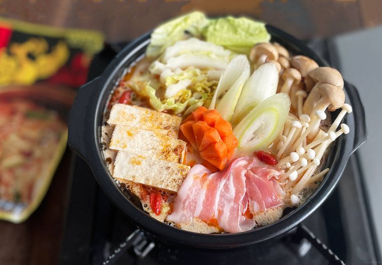 土鍋に鍋の具材を入れて火にかけるところ