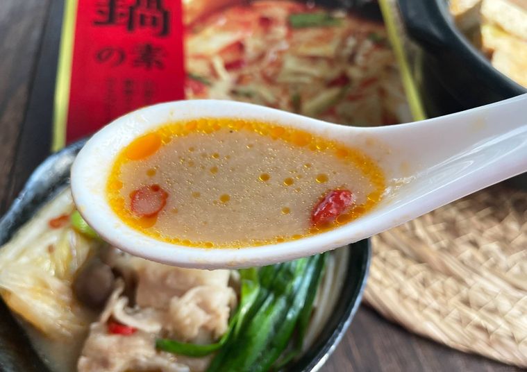 レンゲですくった鍋のスープ