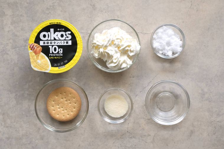オイコス レモンハニーとホイップクリーム、ビスケットなどのレアチーズケーキ風デザートの材料が並んでいる