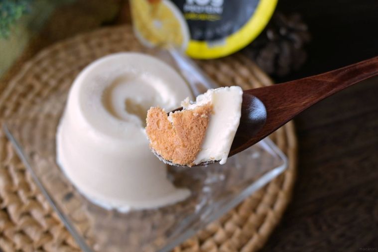 レアチーズケーキ風デザートのボトム部分を木のスプーンですくった様子