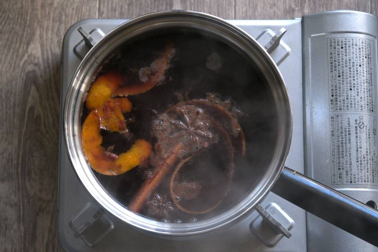 ジュースの中にスパイスやオレンジの皮を浮かぶ、キンダープンシュを作っている鍋