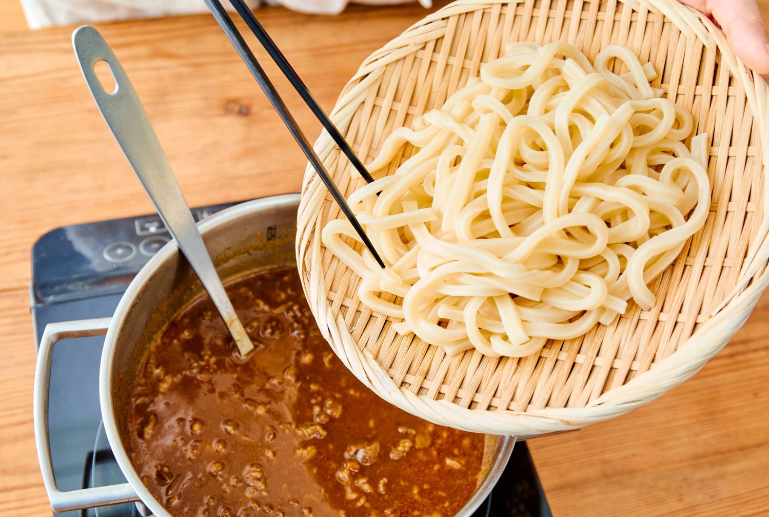 カレー鍋に温めたうどんを入れる