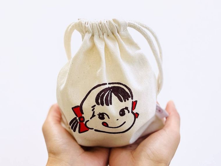 不二家のペコちゃんコットン巾着を両手で持っている様子