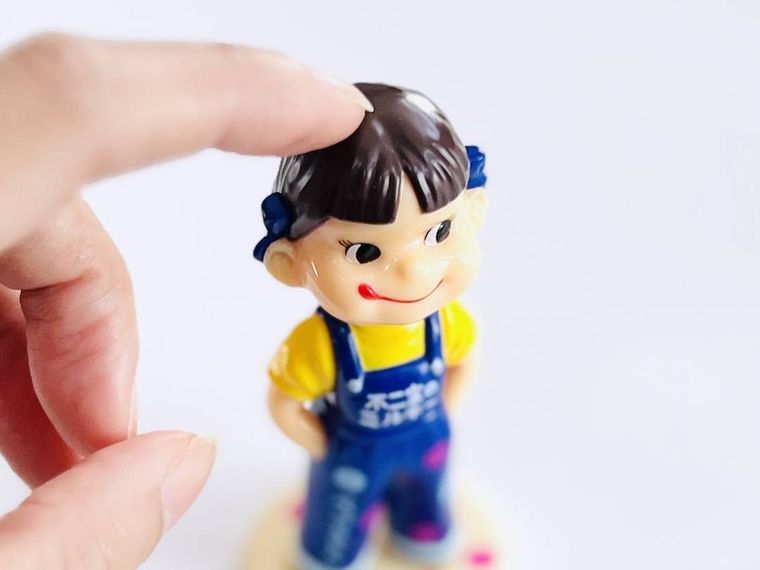 ミニレトロペコちゃん人形の頭を指で触っている様子