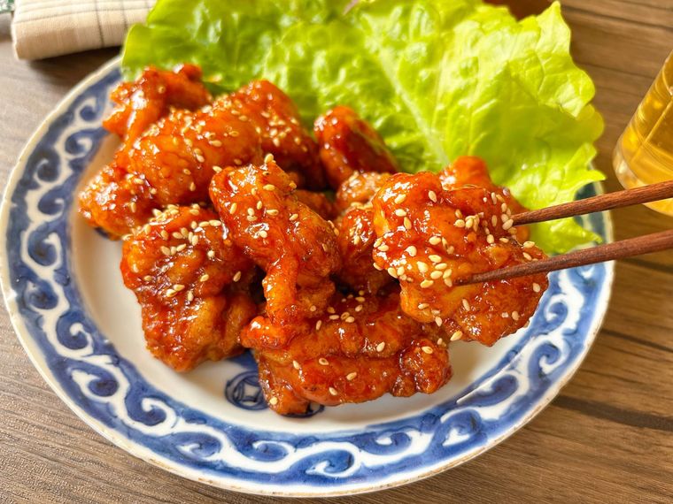和皿に盛られたヤンニョムチキンを箸上げする様子