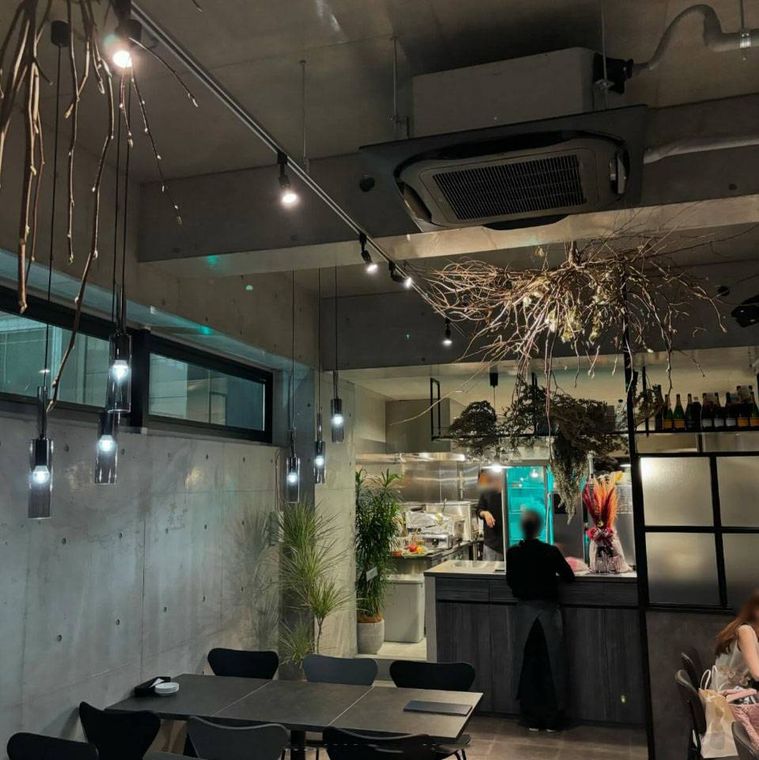 天井からライトや飾りがかけられたトリコミート 難波店の店内