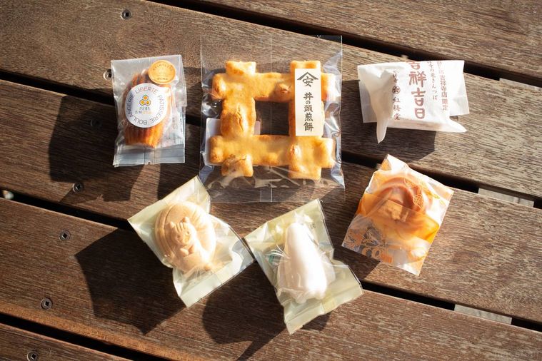 吉祥寺限定のお菓子を木のテーブルの上に並べている様子