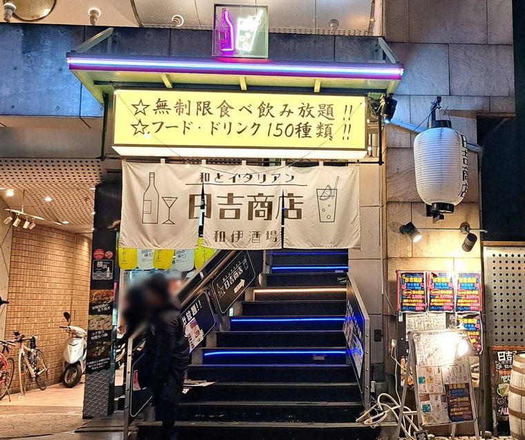黄色の看板と白い暖簾がかかった日吉商店の外観