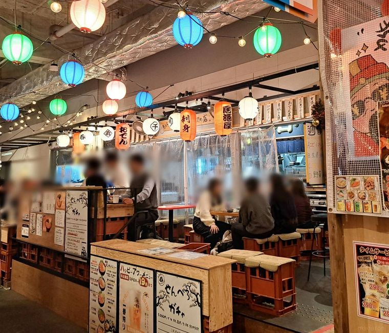 カラフルな提灯とブラウンのカウンター席がならぶ様子