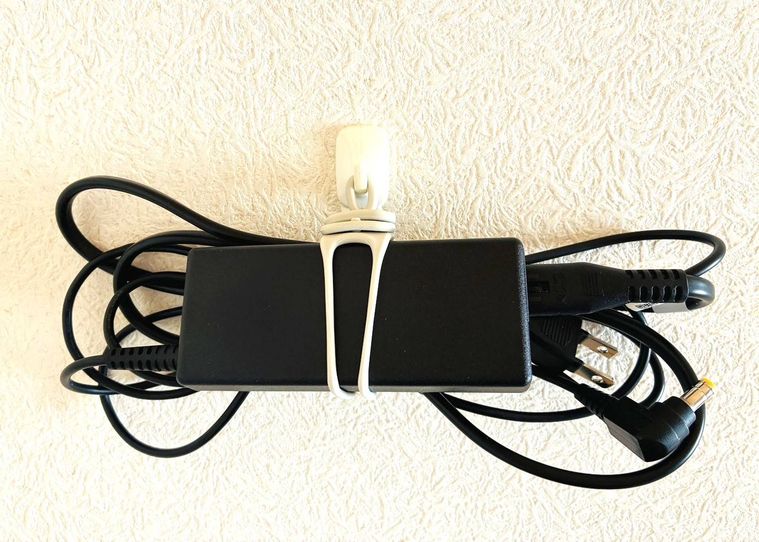 ゴムバンドでまとめたACアダプタをフックに吊り下げている