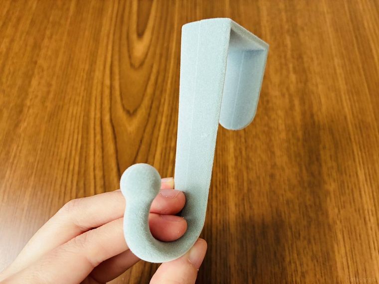 水色のドアフックを手に持っている